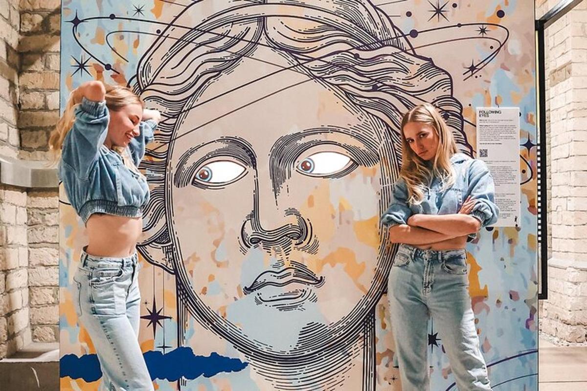 two girls standing in front of a mural of a woman