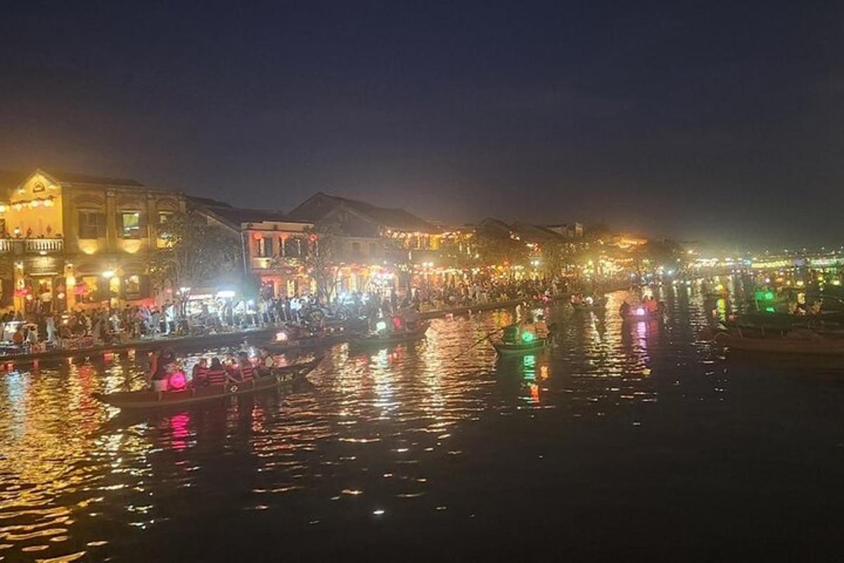 Una ciudad iluminada por la noche con barcos en el agua