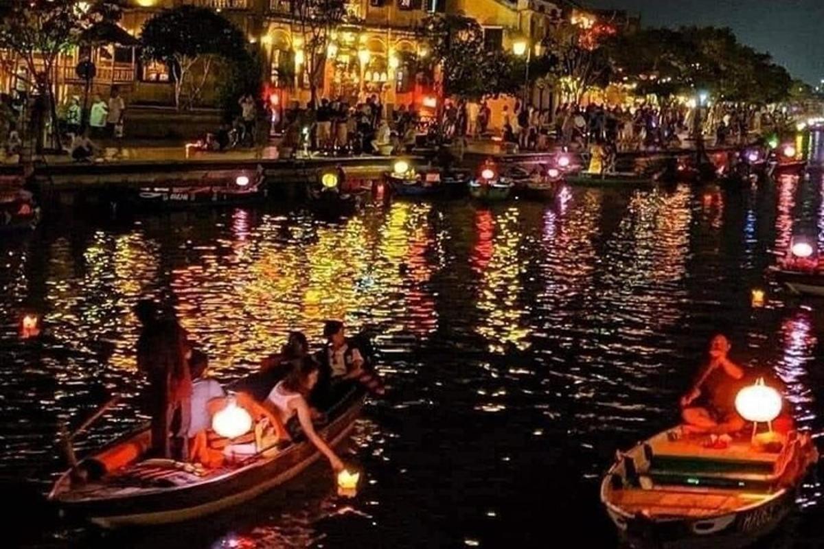 Un grupo de personas en botes en un río por la noche.