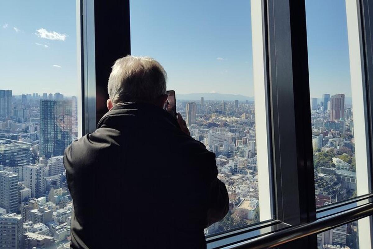 muž fotografující město z vyhlídkového okna