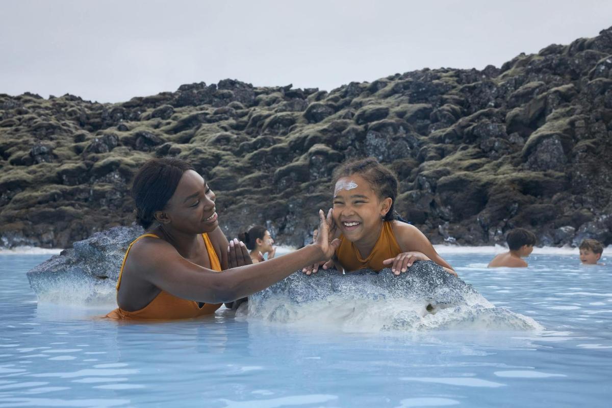 two women playing with a dolphin in the water