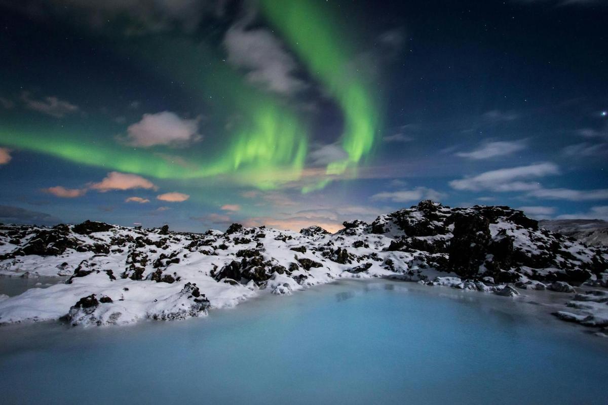 an image of the aurora borealis over a snow covered mountain