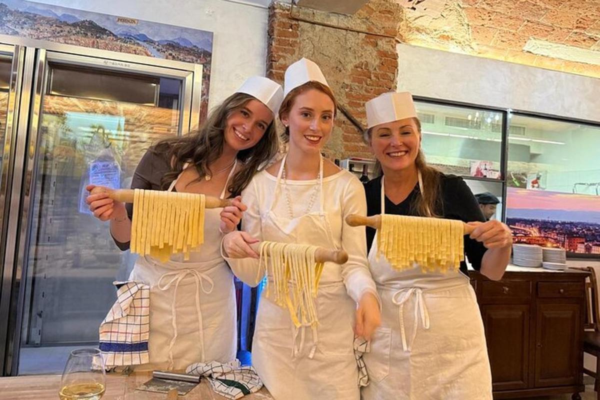 três mulheres em uniformes brancos segurando macarrão