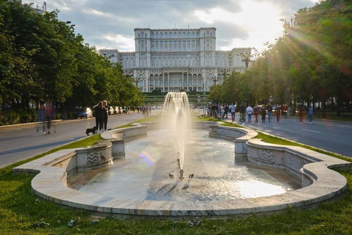 a fountain in a park with a large building in the background