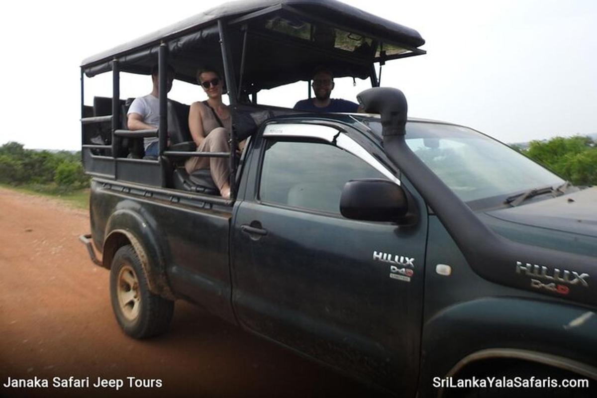 a group of people riding in a vehicle on a dirt road