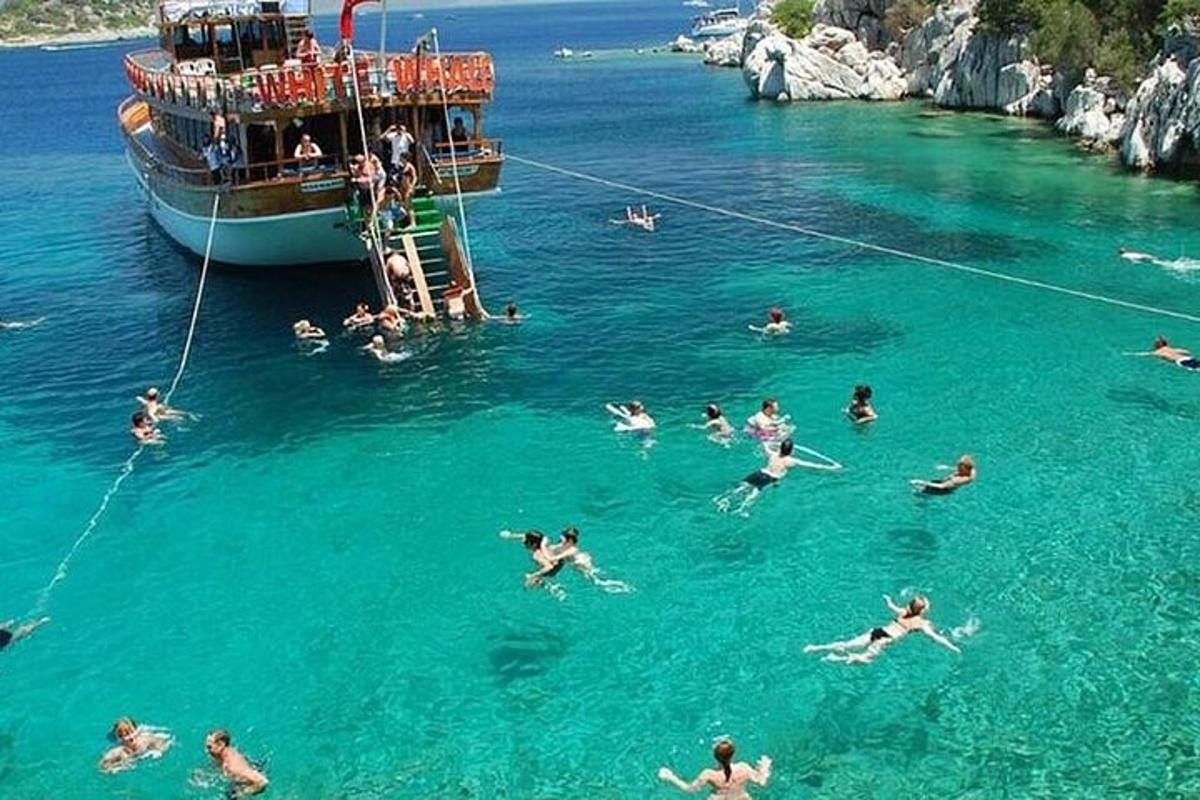 Un grupo de personas en el agua frente a un barco.