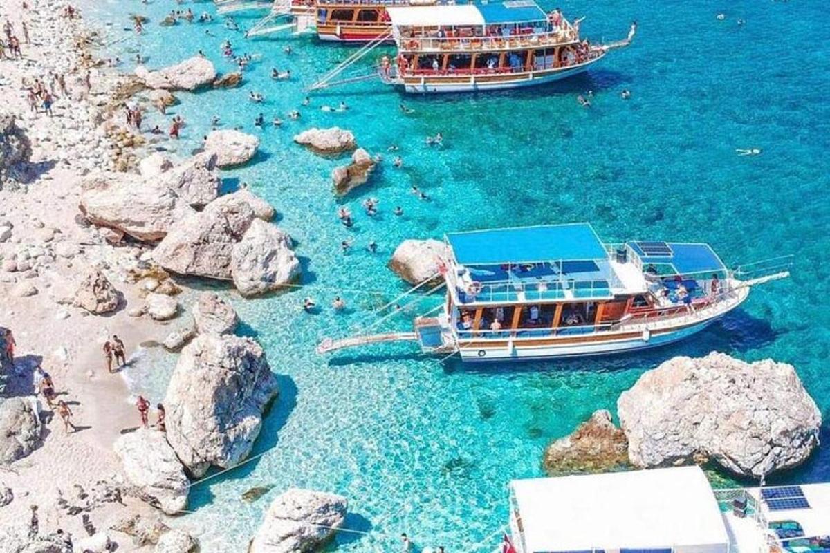 Un grupo de barcos en el agua cerca de las rocas.