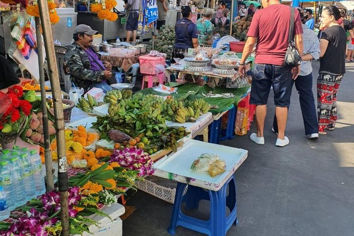 μια ομάδα ανθρώπων που στέκονται γύρω από μια αγορά με φρούτα και λαχανικά