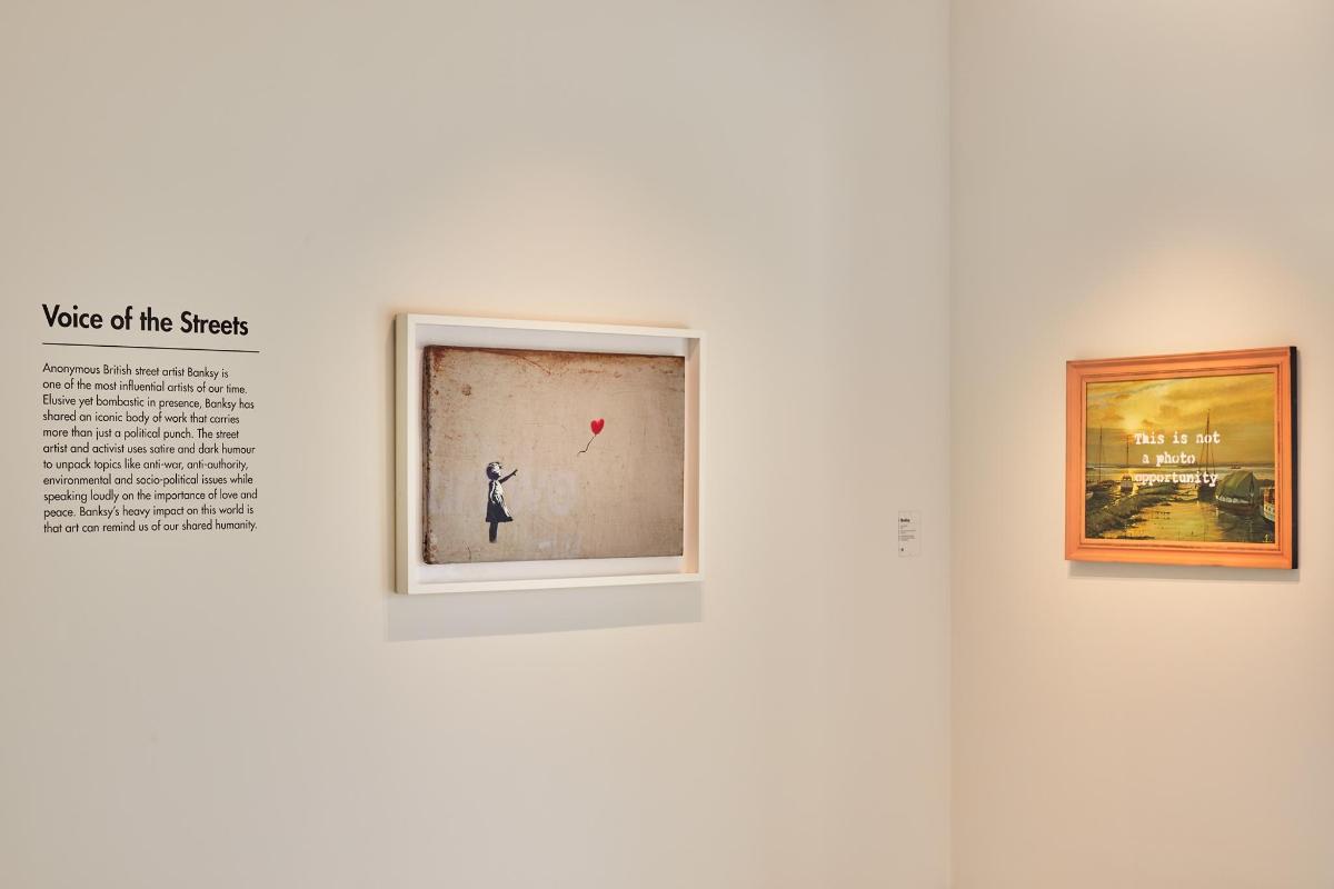 a museum exhibit with two paintings on a wall