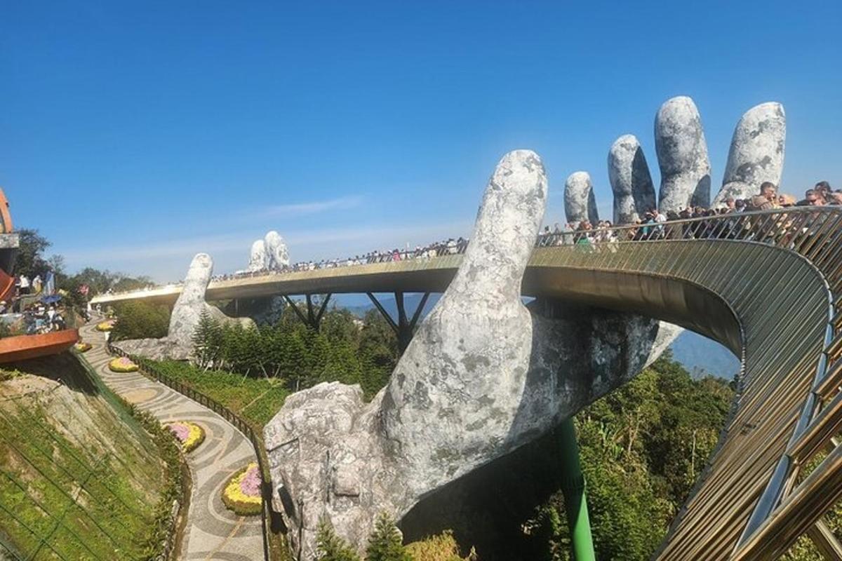 velká skupina lidí přecházejících most s obří rukou