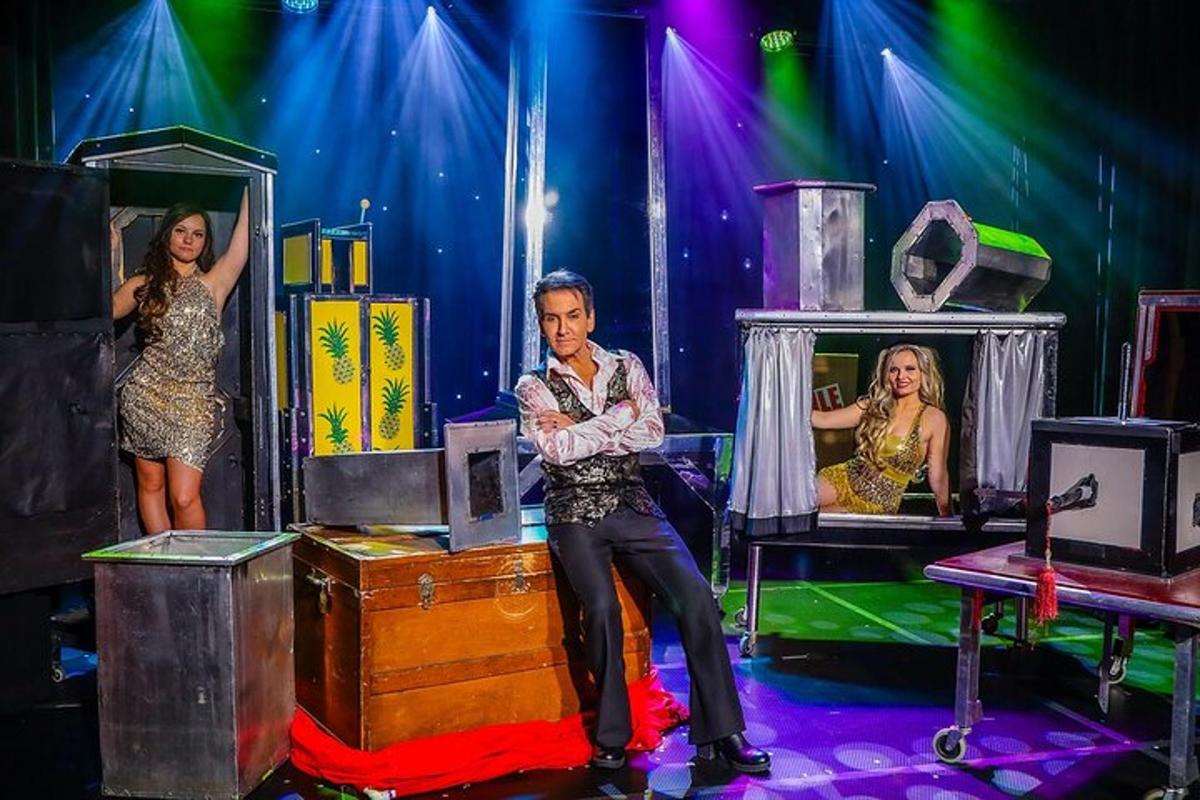 a man and two women on a stage