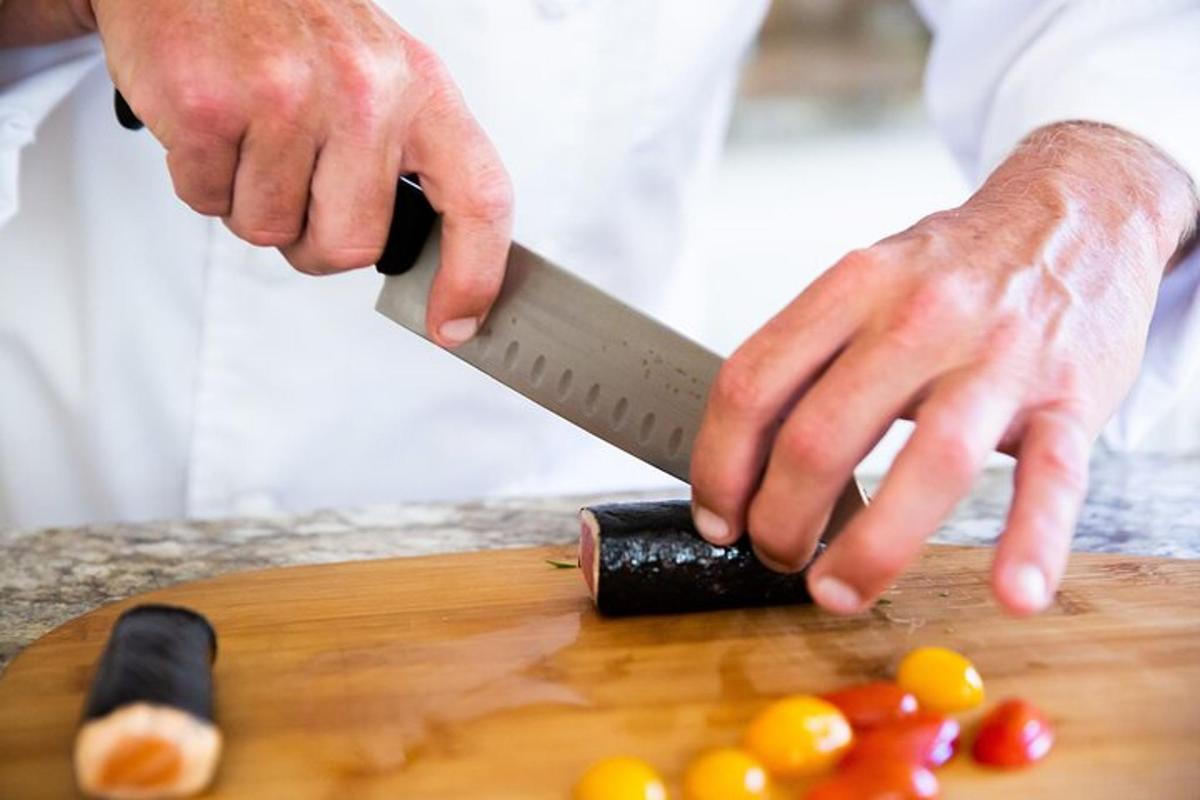 a person cutting tomatoes on a cutting board with a knife