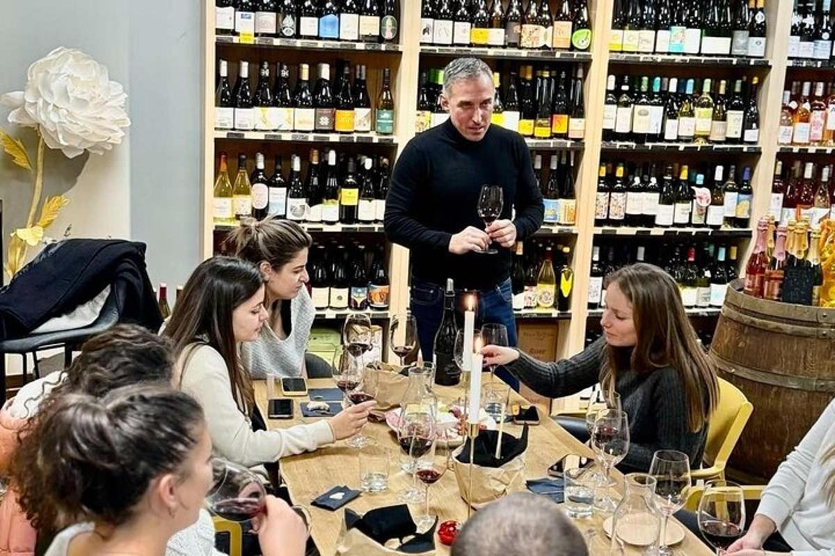 un grup de oameni așezați în jurul unei mese cu pahare de vin