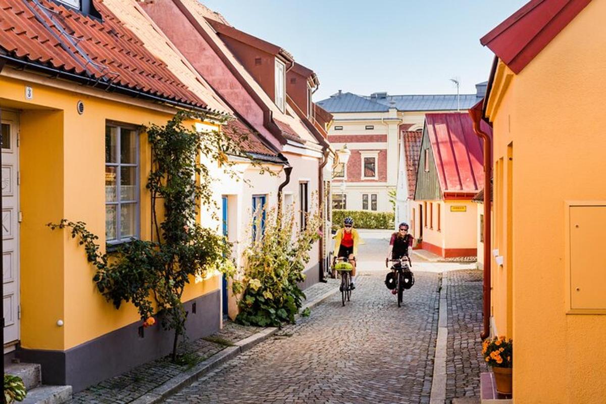 two people riding bikes down a cobblestone street
