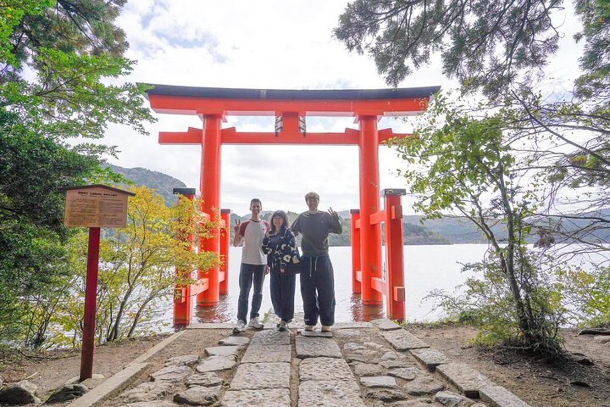 Skupina lidí stojících před bránou torii