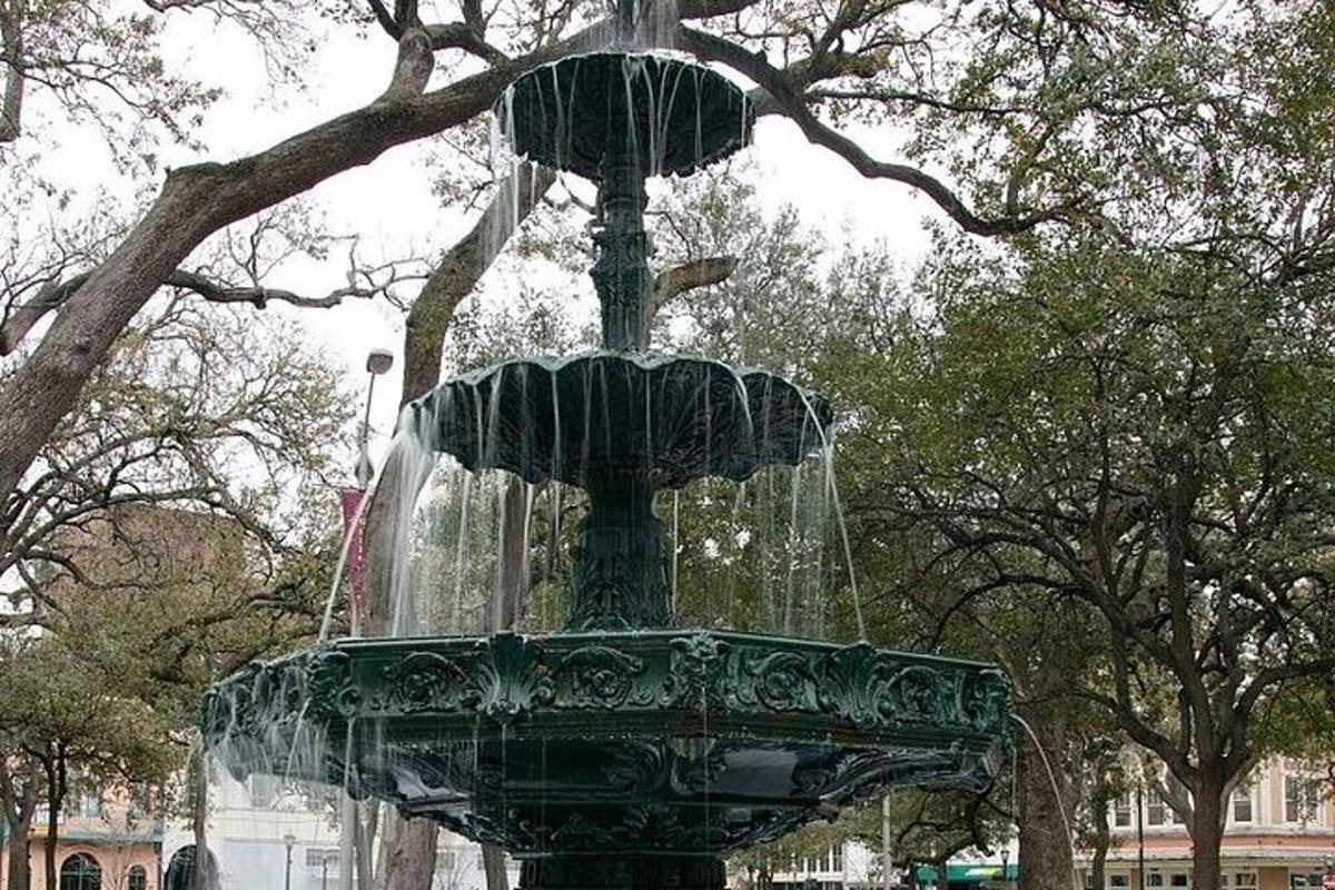 a green fountain in the middle of a park