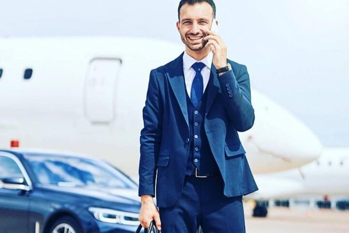a man in a suit and tie talking on a cell phone