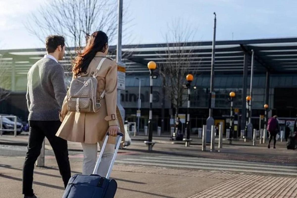 a man and a woman walking with a suitcase