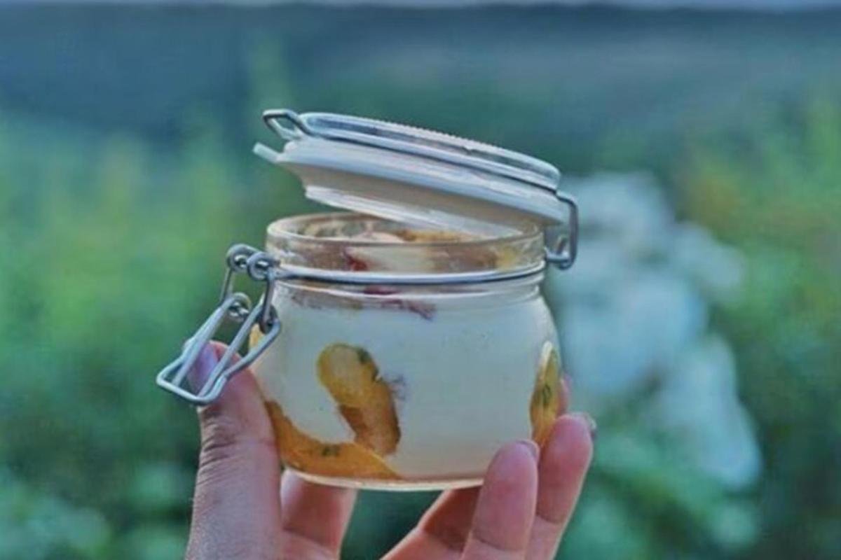 a person holding a jar with a cookie in it