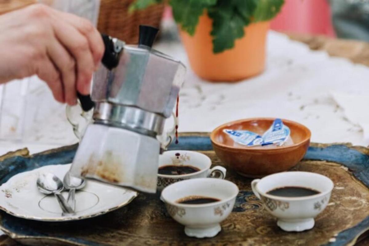 a person pouring coffee into cups on a table