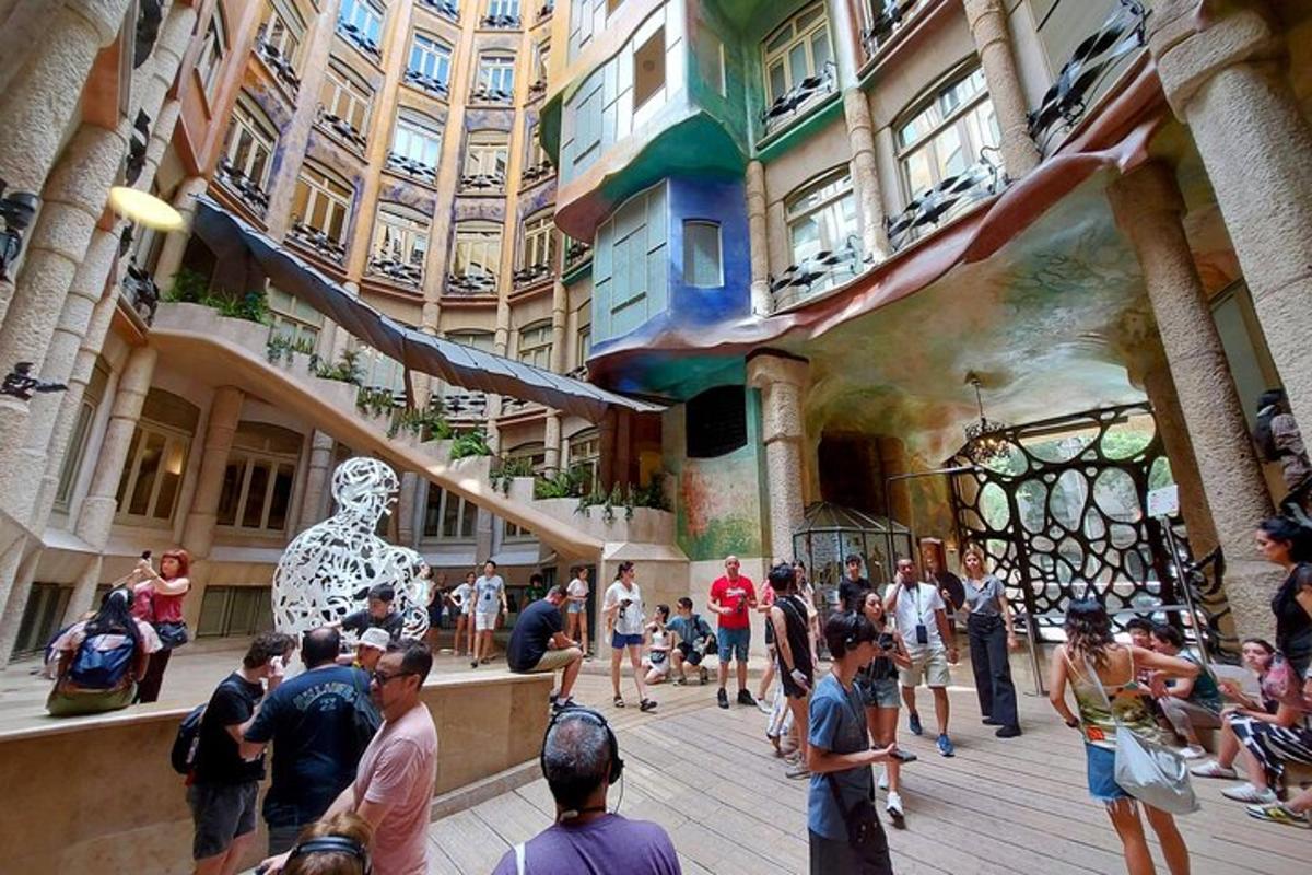 una folla di persone che camminano intorno a un edificio con una statua