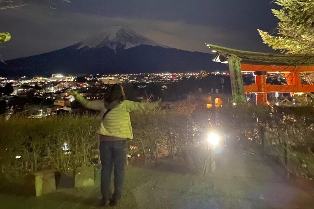 a woman standing on top of a mountain at night