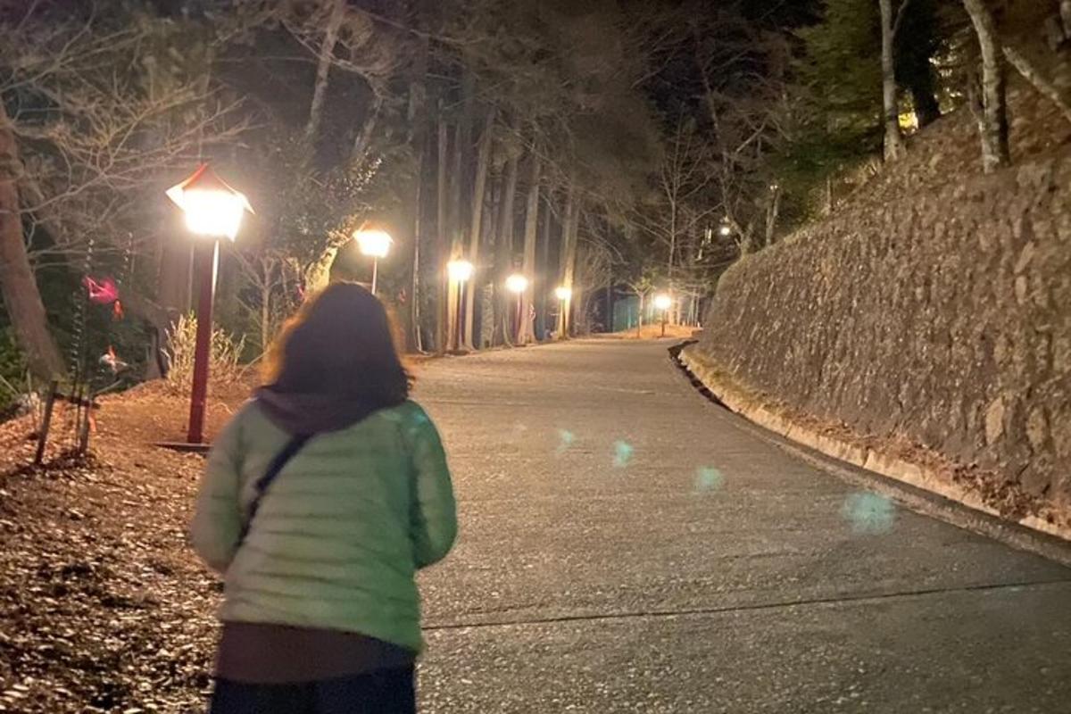a woman walking down a street at night