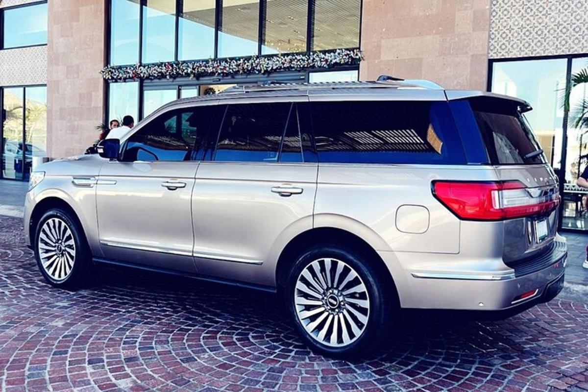 um SUV prateado estacionado em uma rua de tijolos