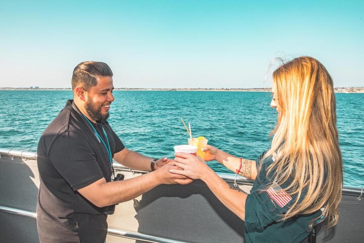 un uomo e una donna che tengono un drink su una barca