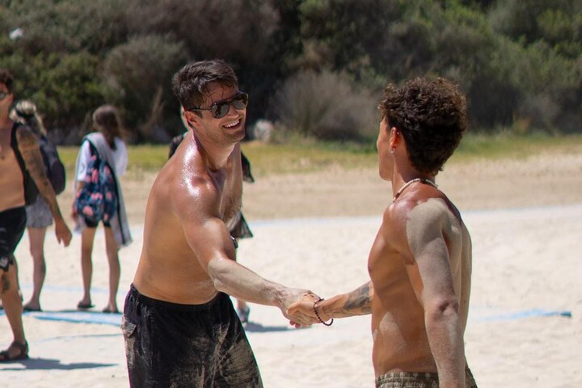 una coppia di uomini si stringe la mano sulla spiaggia