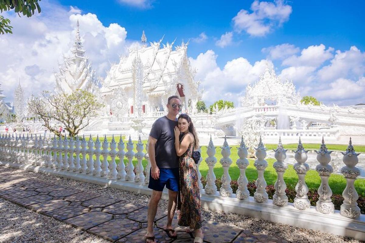a man and woman standing in front of a white temple