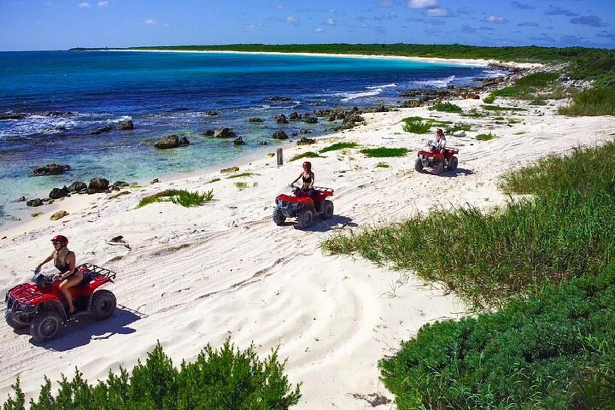 tiga orang menaiki atv di pantai