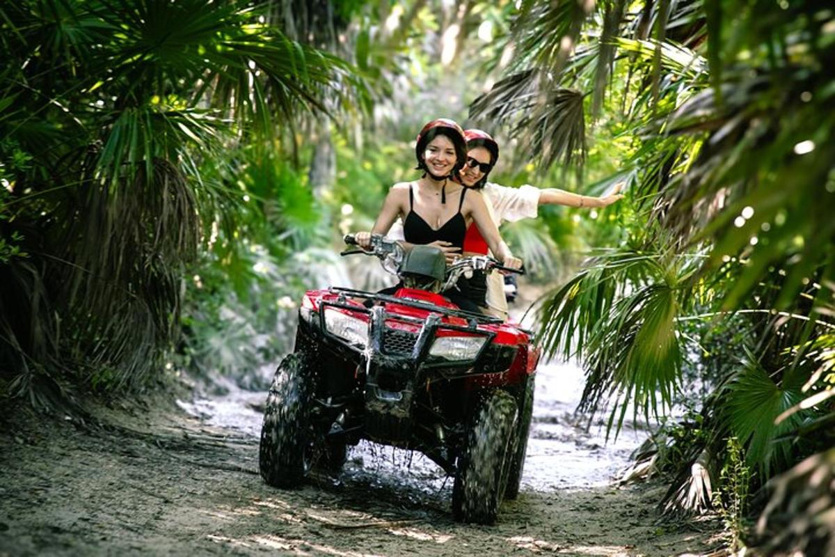 een man en een vrouw rijden op een quad in het bos