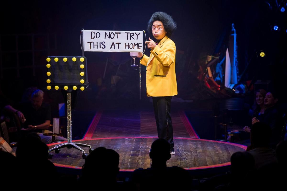 a man standing on a stage holding a sign