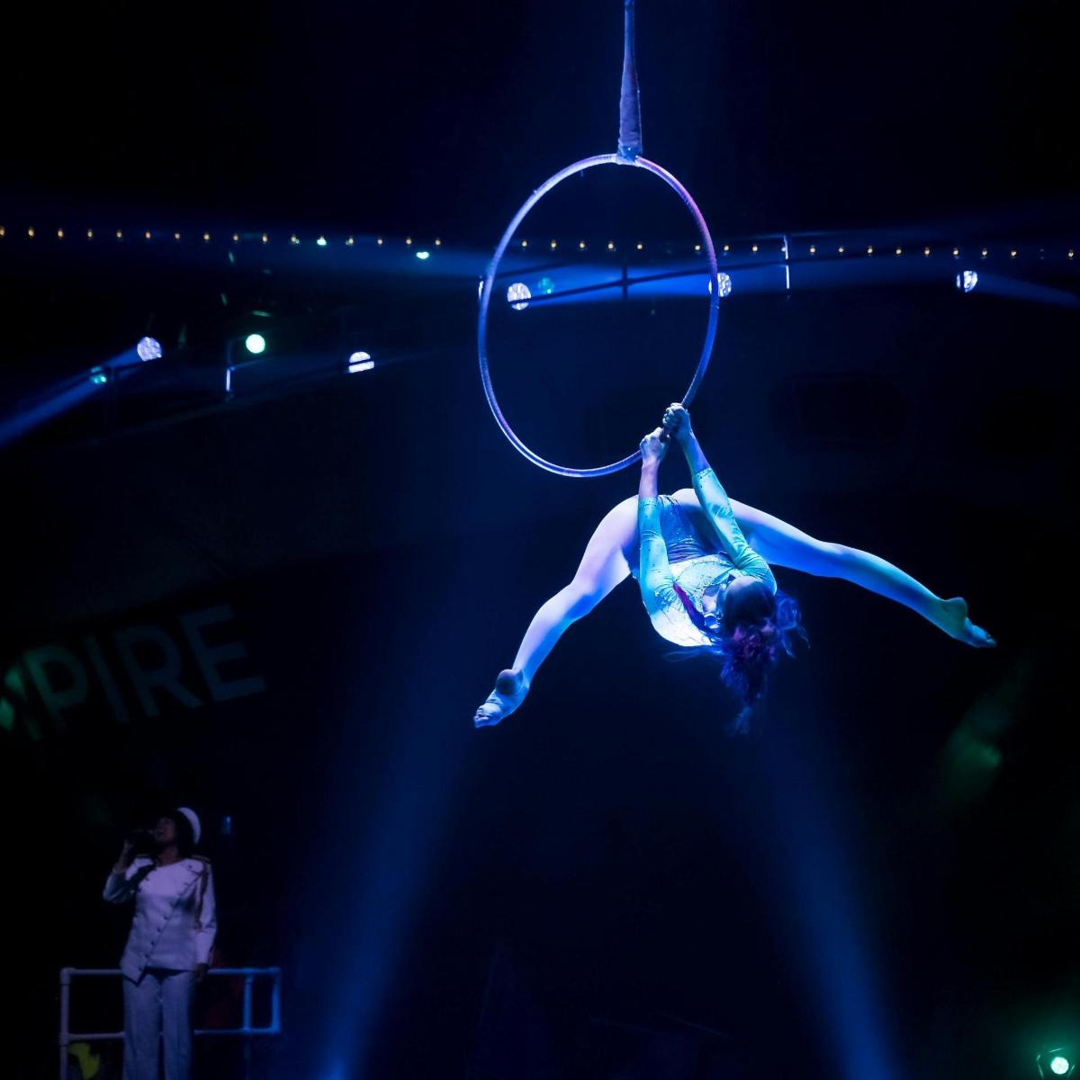 a person is performing on a hoop on a stage