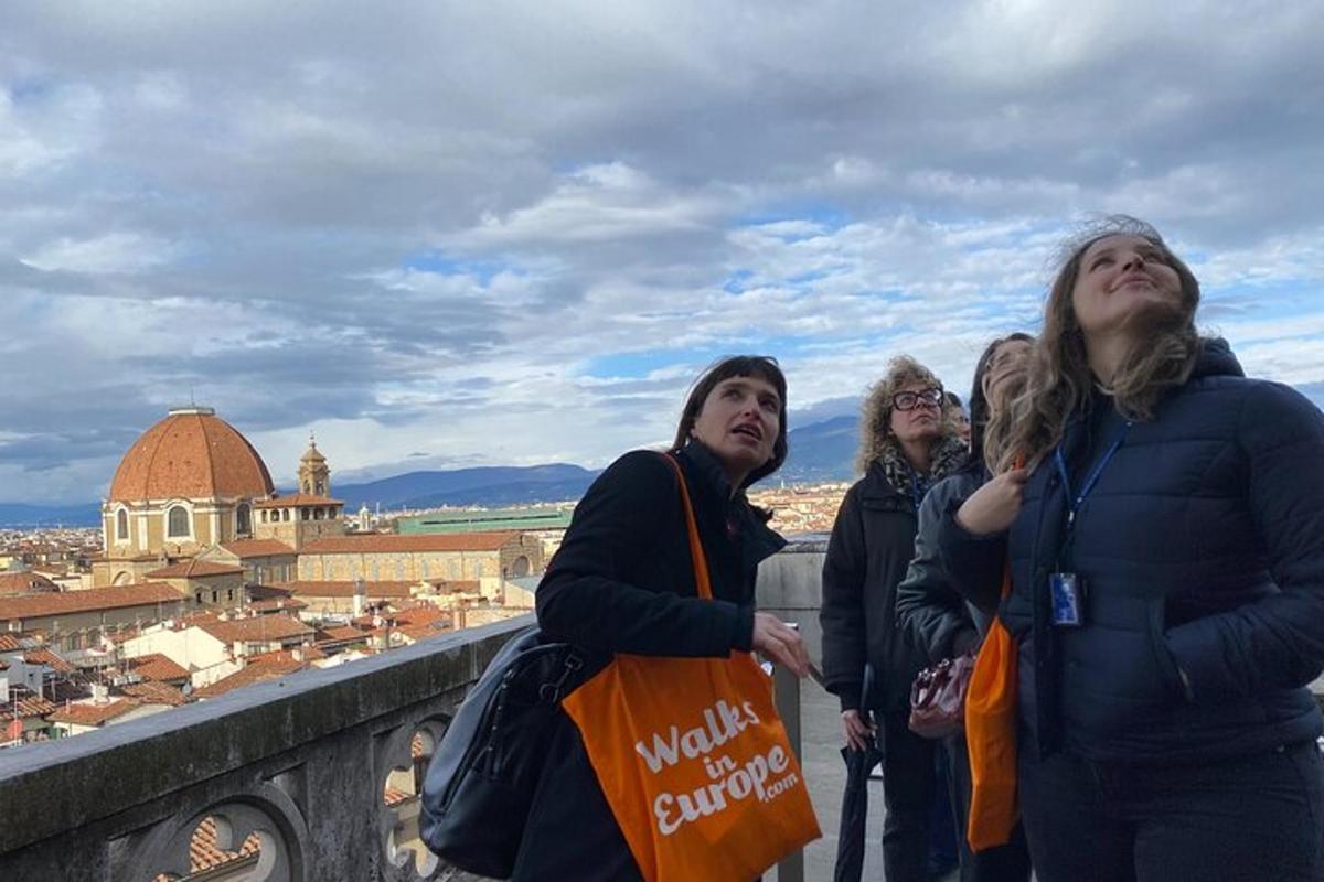 um grupo de mulheres em pé em uma saliência olhando para uma cidade