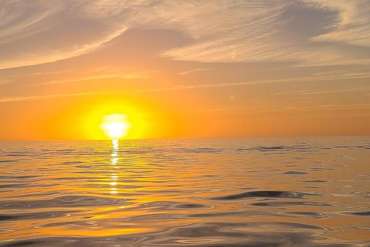 západ slunce nad oceánem se zapadajícím sluncem