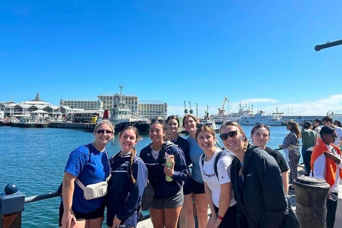 a group of women posing for a picture by the water