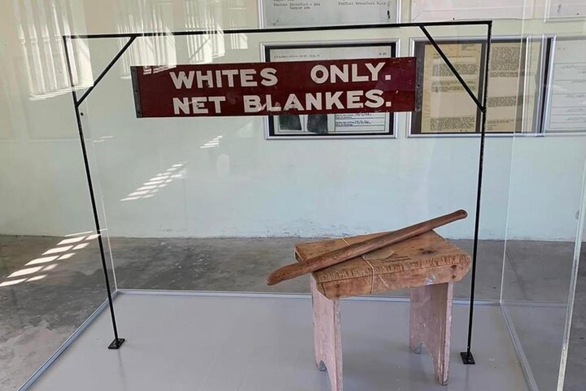 a sign that reads whites only net blazes next to a bench