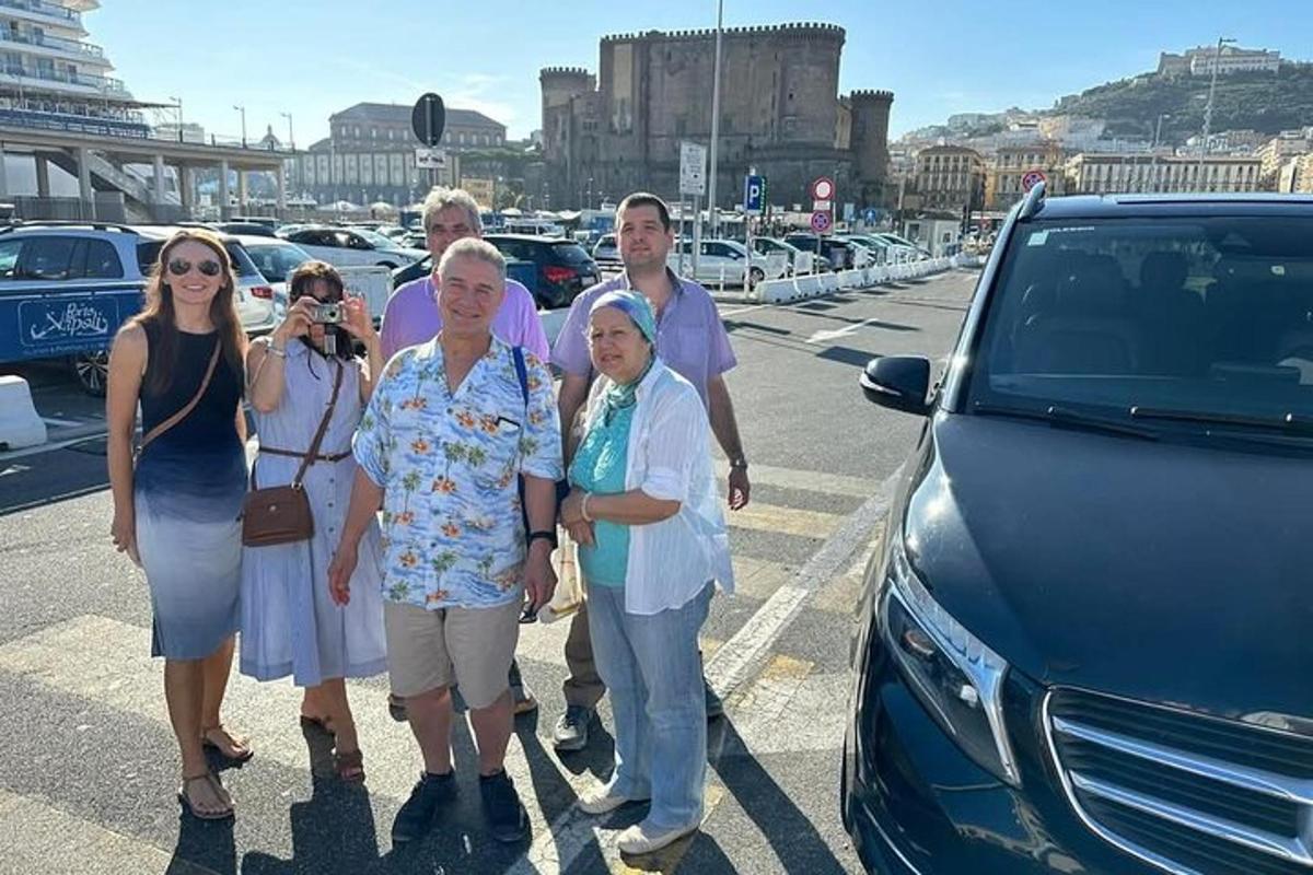 skupina lidí stojících před autem