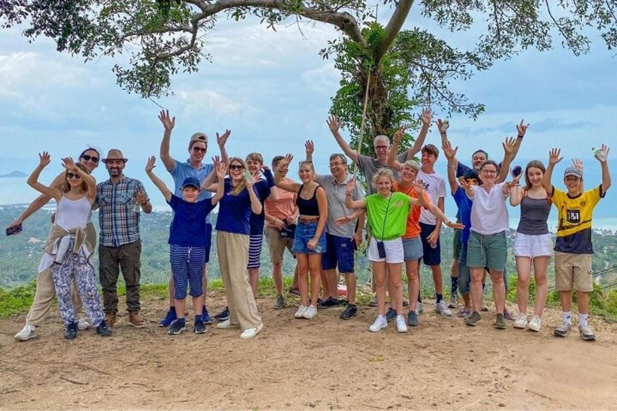 a group of people standing on a hill with their hands in the air