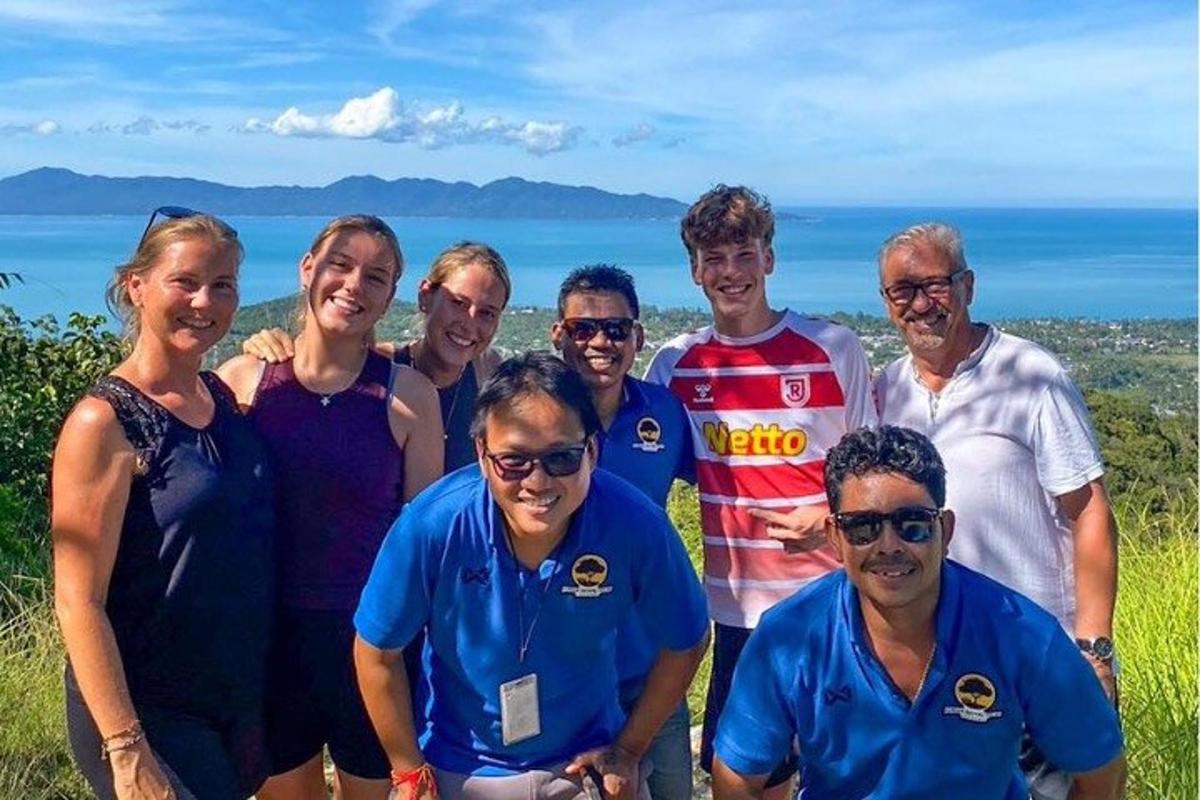 a group of people posing for a picture in front of the ocean