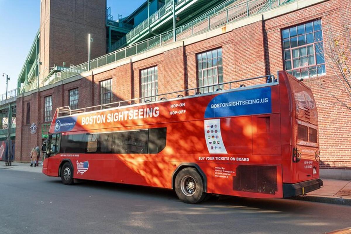 punane kahekordne buss pargitud telliskivihoone ette