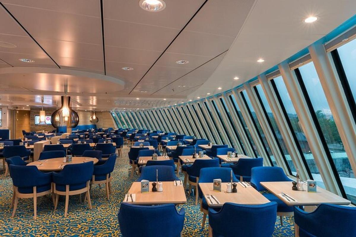 uma sala de jantar em um navio de cruzeiro com mesas e cadeiras