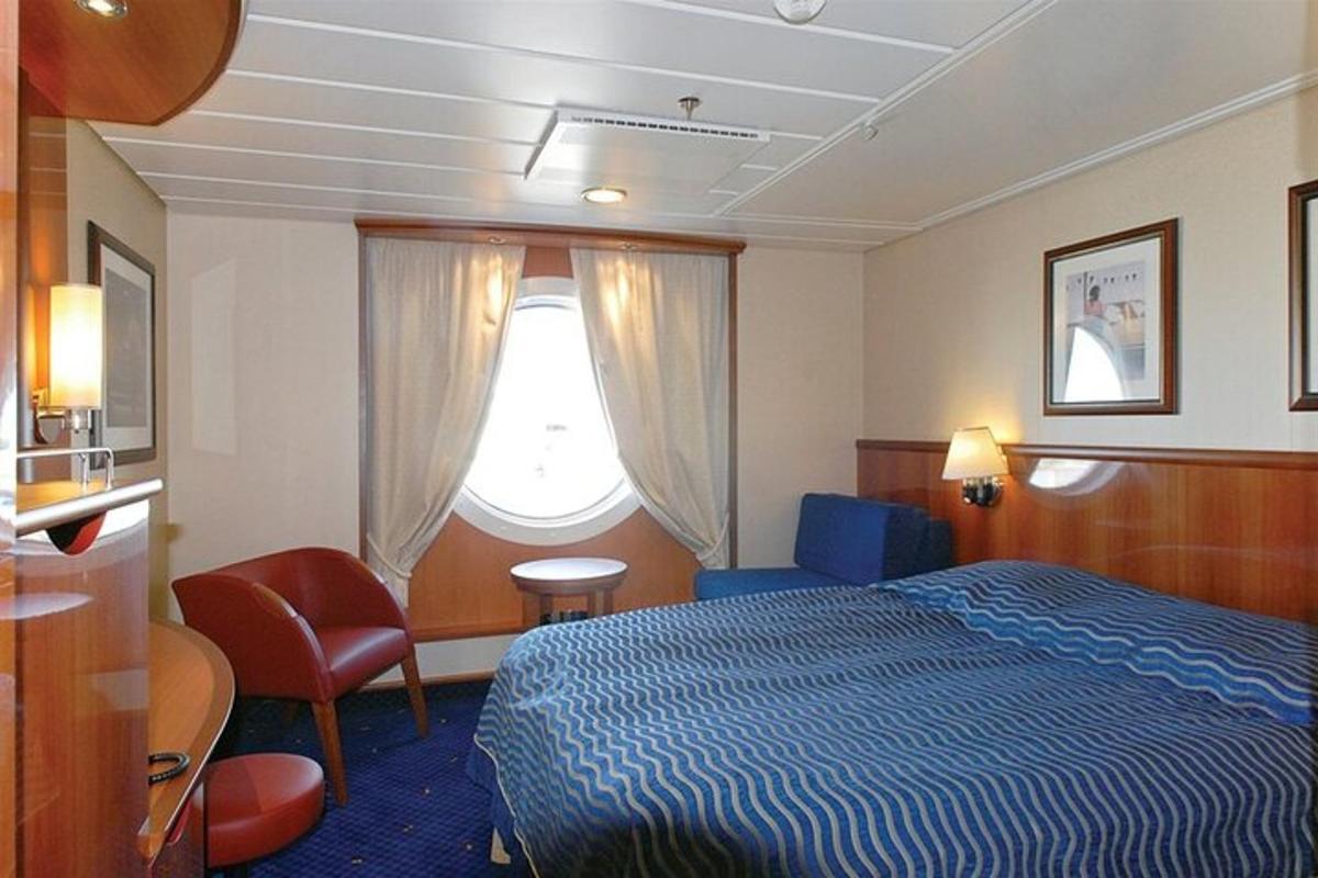um quarto de hotel com uma cama e uma janela