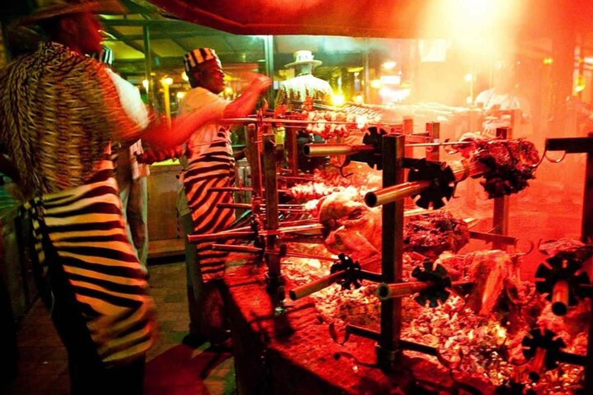 dues persones dempeus a la cuina preparant menjar
