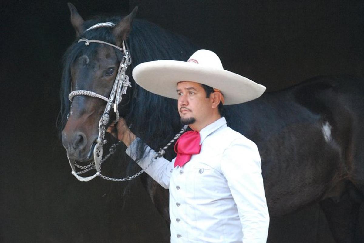 een man met een cowboyhoed die naast een paard staat