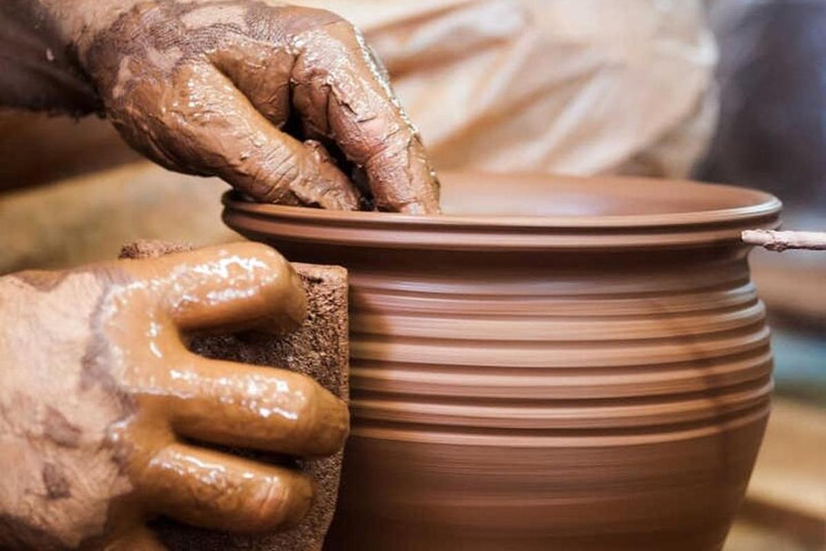 a person making a pot on a pottery wheel
