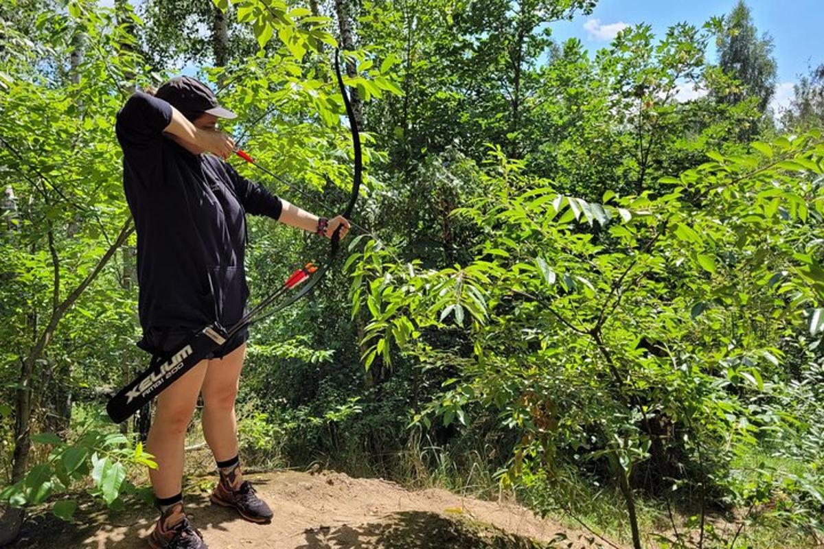 a person is using a bow and arrow in the woods