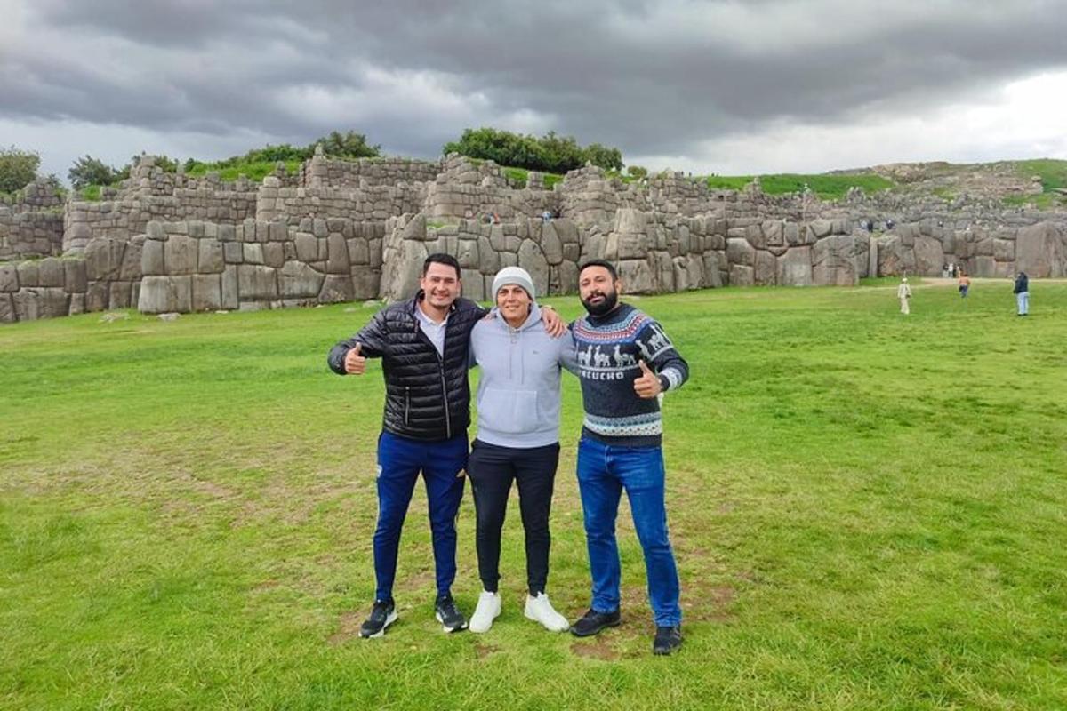 tre persone posano per una foto davanti a una parete rocciosa